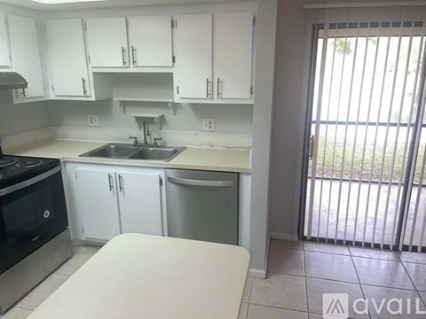 A kitchen with white cabinets and a black stove top oven.