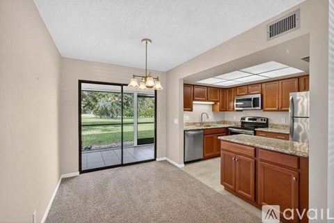 A kitchen with a microwave, oven, and sink is visible through a glass door.
