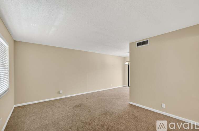 A room with beige walls and carpeted floor.