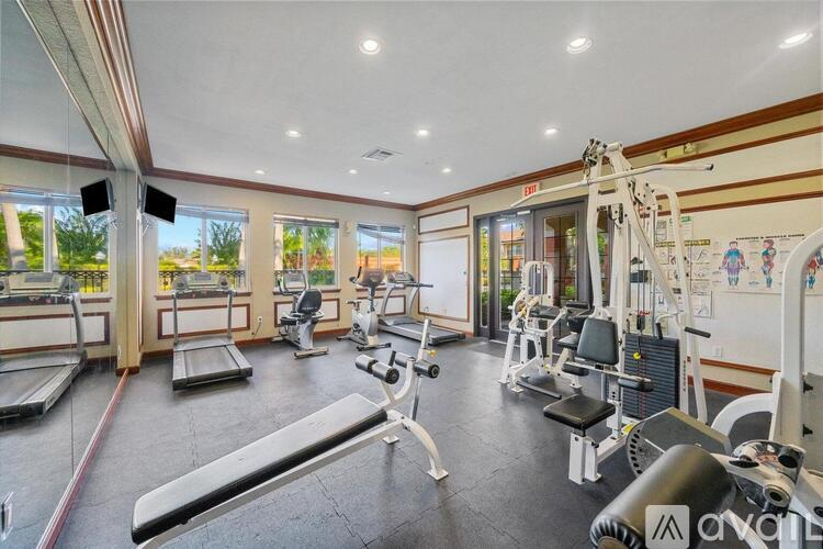 A well-equipped gym with various exercise machines and a large mirror on the wall.