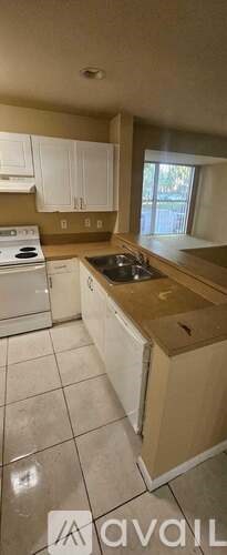 A kitchen with white cabinets and a beige countertop.