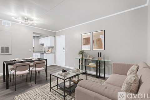A modern living room with a glass coffee table and a grey sofa.