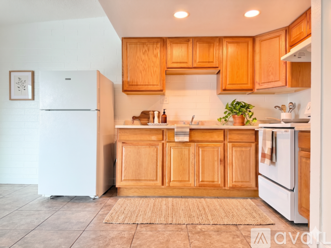 A kitchen with wooden cabinets and white appliances.