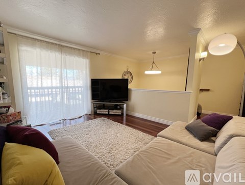 A living room with a white couch and a flat screen TV.