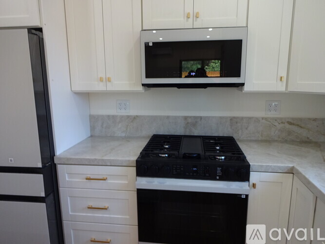 A kitchen with a black stove top oven and white cabinets.