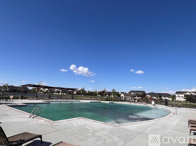 A large outdoor swimming pool with a slide and sun loungers.