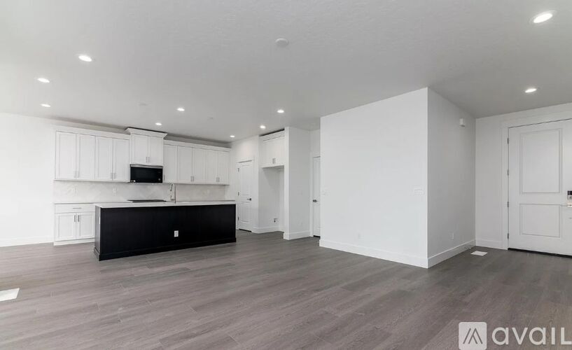 A spacious room with a black countertop and white cabinets.