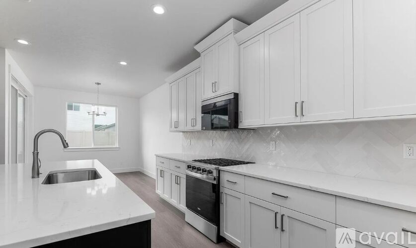 A modern kitchen with white cabinets and appliances.