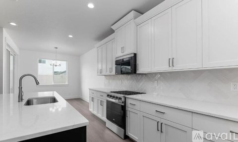 A modern kitchen with white cabinets and appliances.