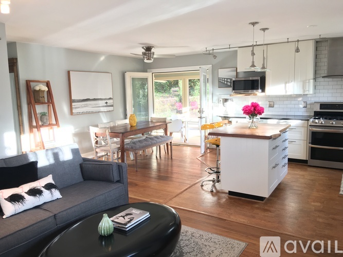 A modern kitchen with a grey couch and a black coffee table.