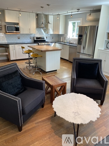 A modern kitchen with a breakfast bar and two chairs.