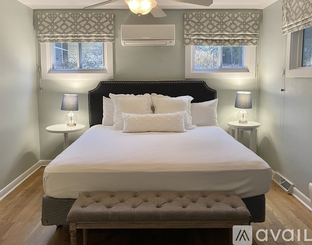 A bedroom with a large bed and a ceiling fan.