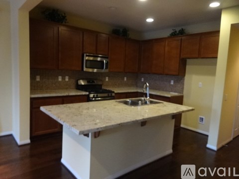 A kitchen with brown cabinets and a granite countertop.
