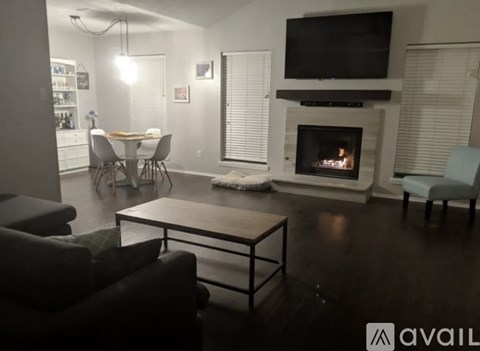 A living room with a fireplace and a television mounted above it.