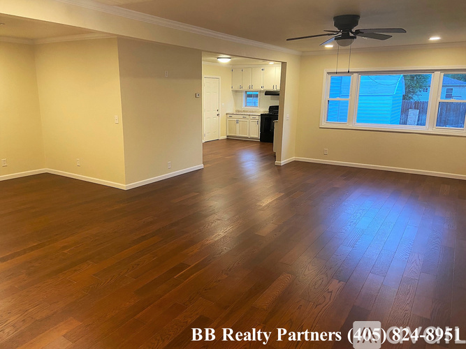 A room with wooden flooring and a ceiling fan.
