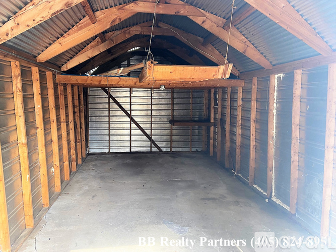 A large, empty attic space with wooden beams and a metal staircase.