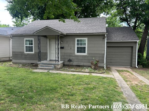A small house with a BB Realty Partners sign in front.