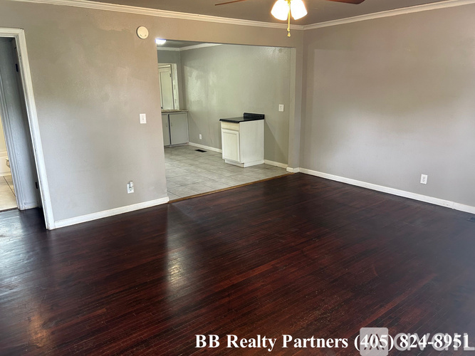 A room with wood flooring and a ceiling fan.