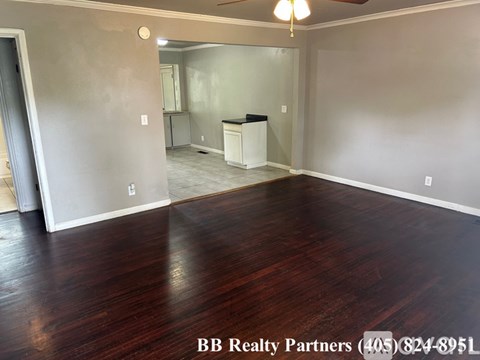 A room with wood flooring and a ceiling fan.