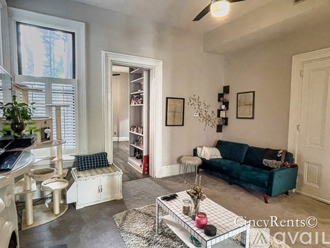 A living room with a blue couch and a glass coffee table.