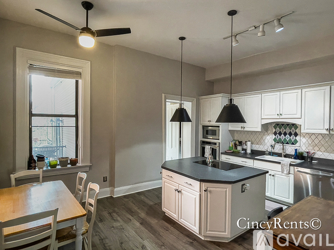 A kitchen with a table and chairs by a window.