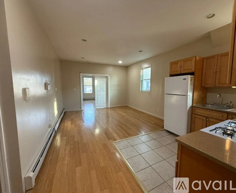 A kitchen with wooden floors and a white refrigerator.