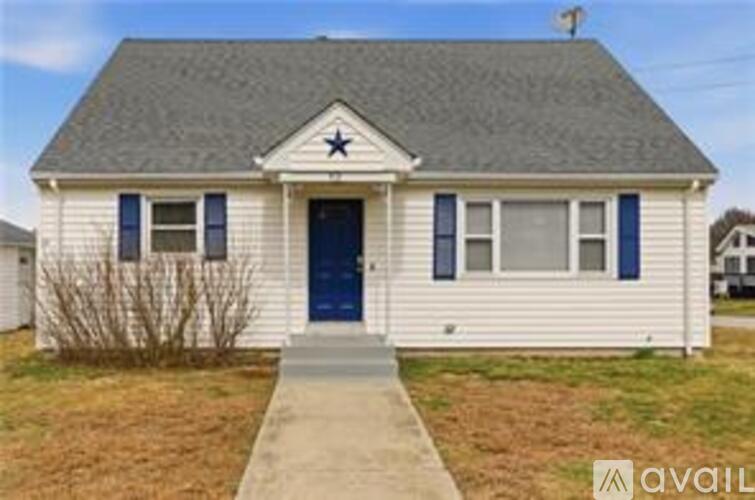 A small house with a dark blue door and a star on the roof.