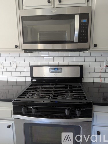 A modern kitchen with a stove top oven and microwave above it.