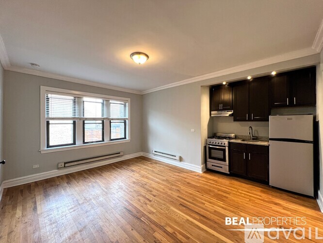 A spacious kitchen with wooden floors and a window.