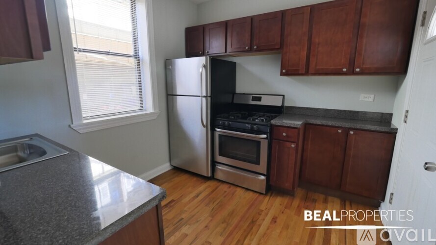 A kitchen with wooden cabinets and a stainless steel refrigerator.