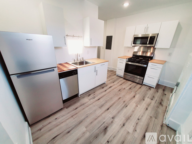 A kitchen with a refrigerator, sink, and stove.
