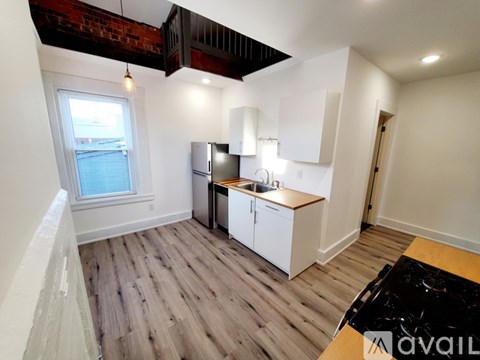 A kitchen with white cabinets and a wooden countertop.