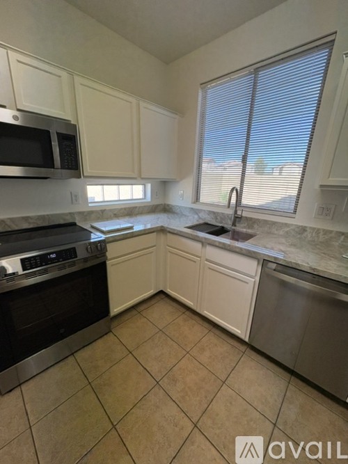 A kitchen with white cabinets and a black oven.