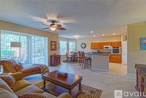 A living room with a brown coffee table and a ceiling fan.