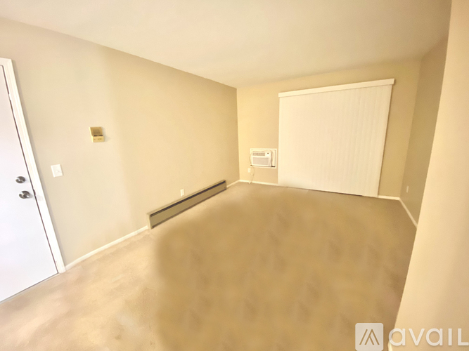 A room with a white door and a window with blinds.
