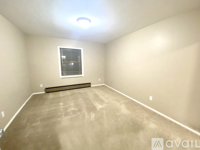 A spacious room with a window and a bench.