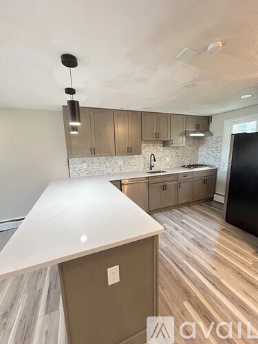 A kitchen with wooden floors and a white countertop.