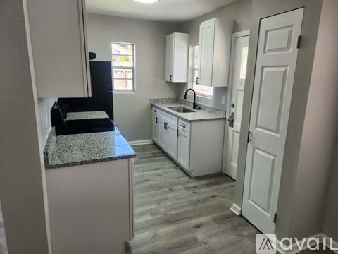 A kitchen with a granite countertop and white cabinets.