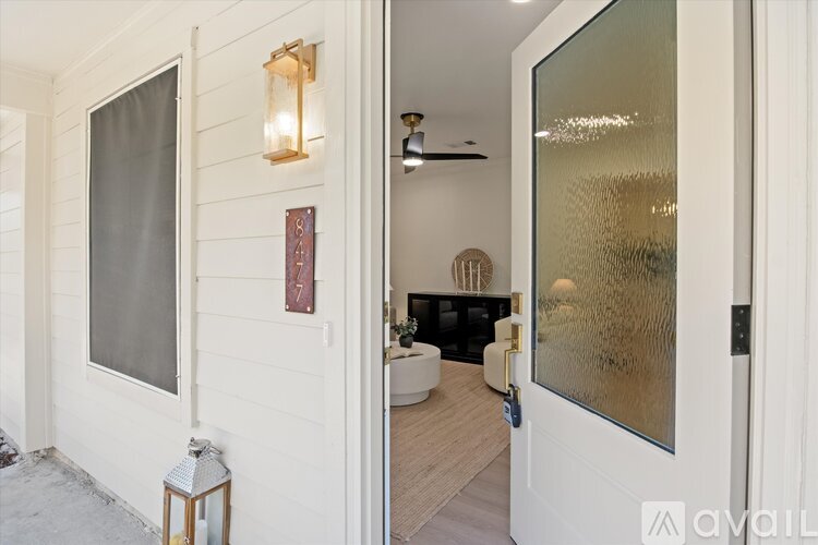 A modern interior with a glass door leading to a living area.