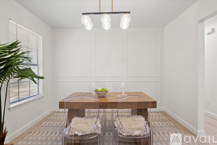 A dining room with a wooden table and chairs.