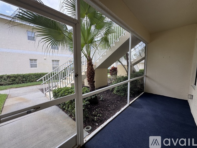 A balcony with a view of a building and a palm tree.
