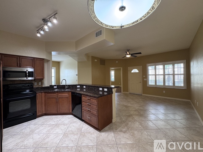 A kitchen with a black oven and brown cabinets.