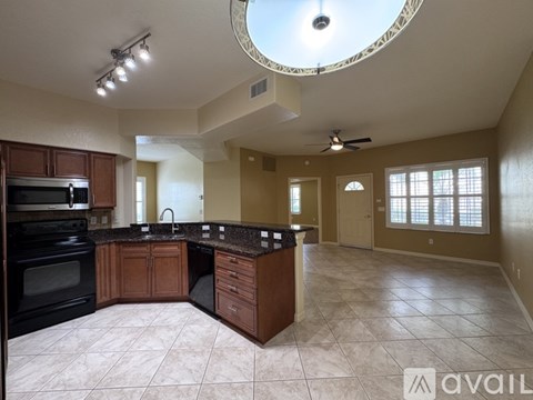 A kitchen with a black oven and brown cabinets.