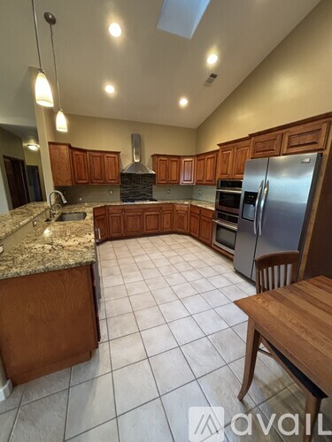 A kitchen with a granite countertop and wooden cabinets.