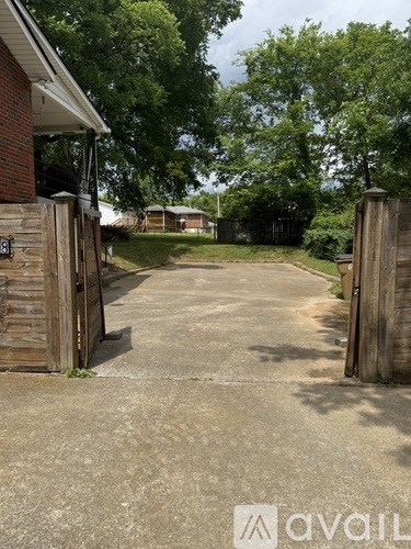 A driveway leads to a house with a wooden gate.