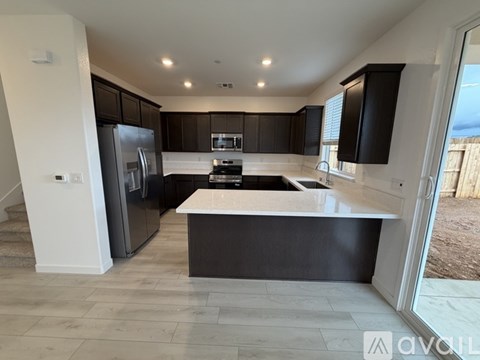 A modern kitchen with dark brown cabinets and a white island.