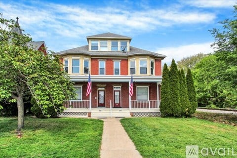 A red brick house with a flag on the front porch.