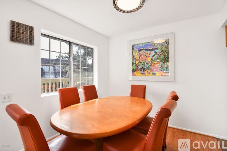 A dining room with a wooden table and chairs.
