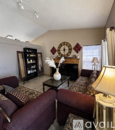 A living room with a dark brown sofa and a white vase on a coffee table.