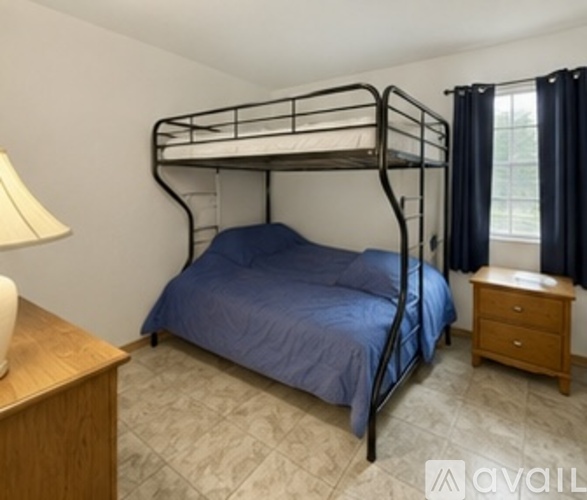 A bedroom with a bunk bed and a nightstand.